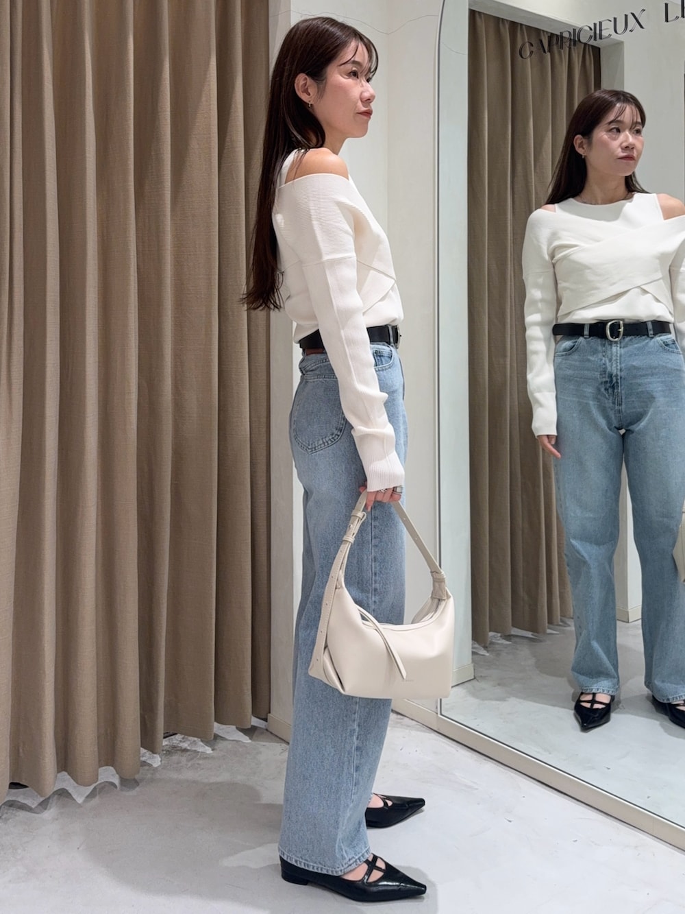 ホワイト系のニット/セーター、ブラック系のパンプス、ホワイト系のショルダーバッグを着用したレディースの冬コーディネートの5枚目の写真