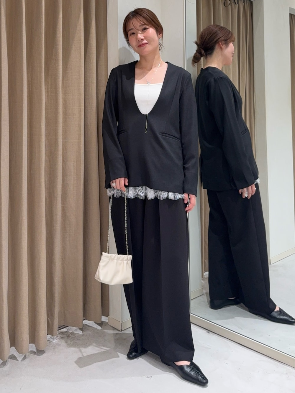 ブラック系のトップス、ホワイト系のキャミソール、ホワイト系のショルダーバッグを着用したレディースの春コーディネートの2枚目の写真