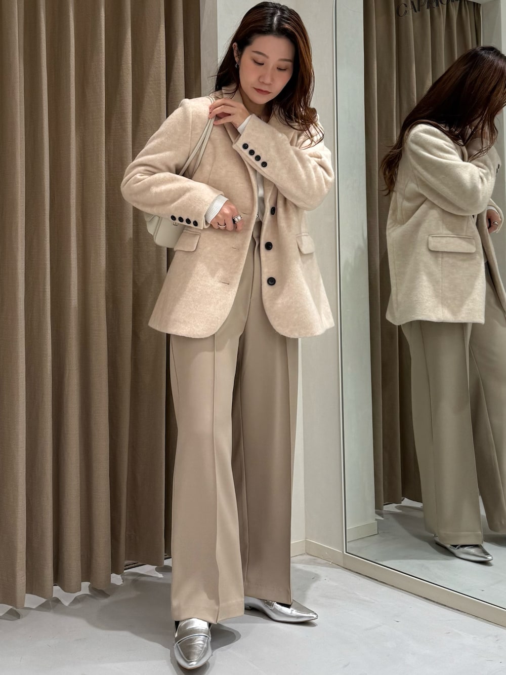 ベージュ系のテーラードジャケット、ホワイト系のニット/セーター、ベージュ系のその他パンツを着用したレディースの冬コーディネートの2枚目の写真