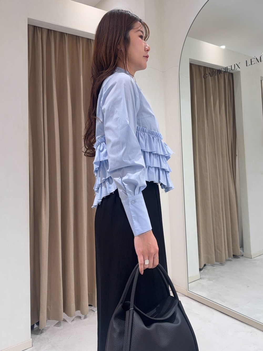 ブルー系のシャツ/ブラウス、ブラック系のショルダーバッグ、ブラック系のスカートを着用したレディースの冬コーディネートの6枚目の写真