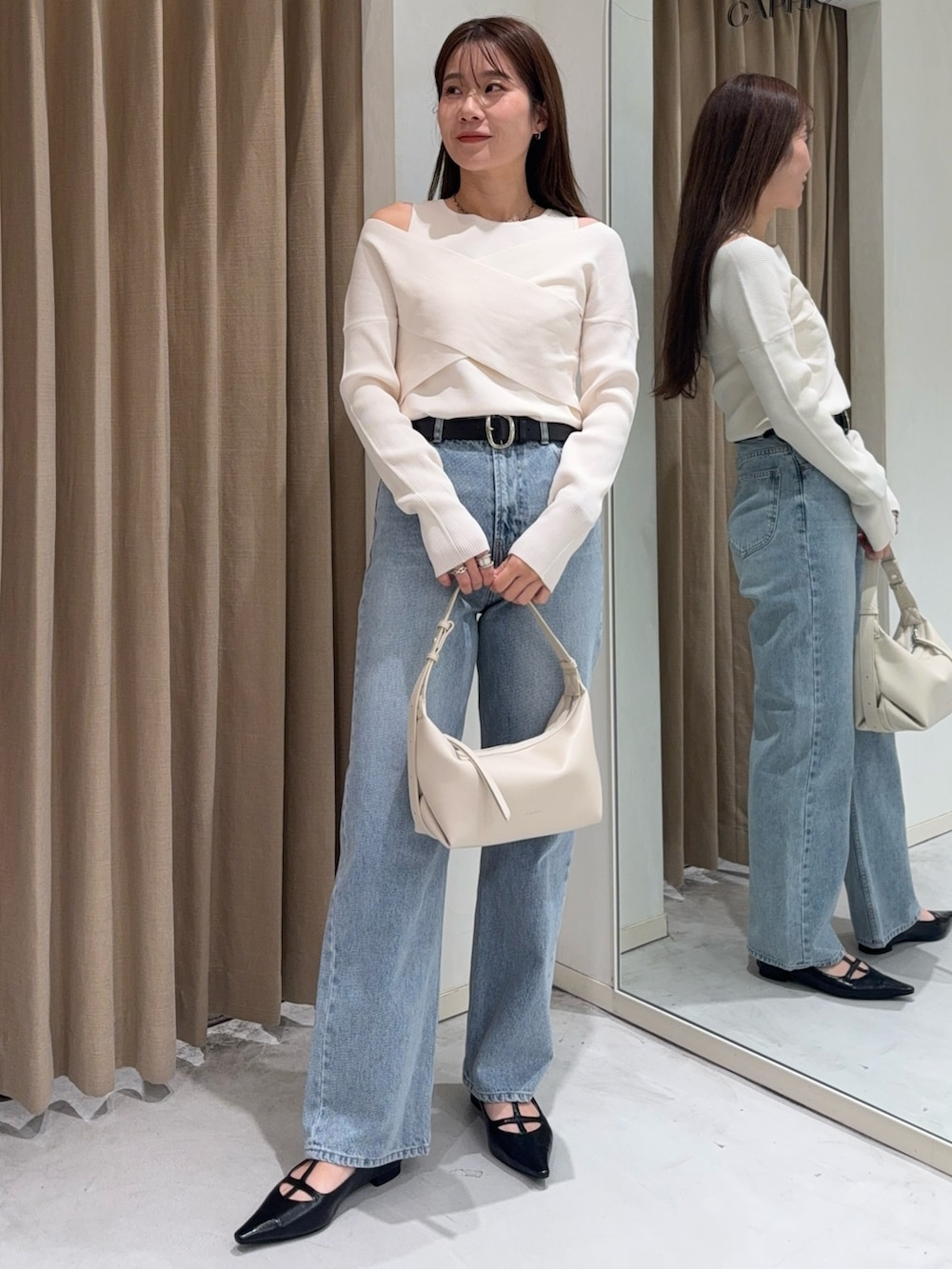 ホワイト系のニット/セーター、ブラック系のパンプス、ホワイト系のショルダーバッグを着用したレディースの冬コーディネートの2枚目の写真