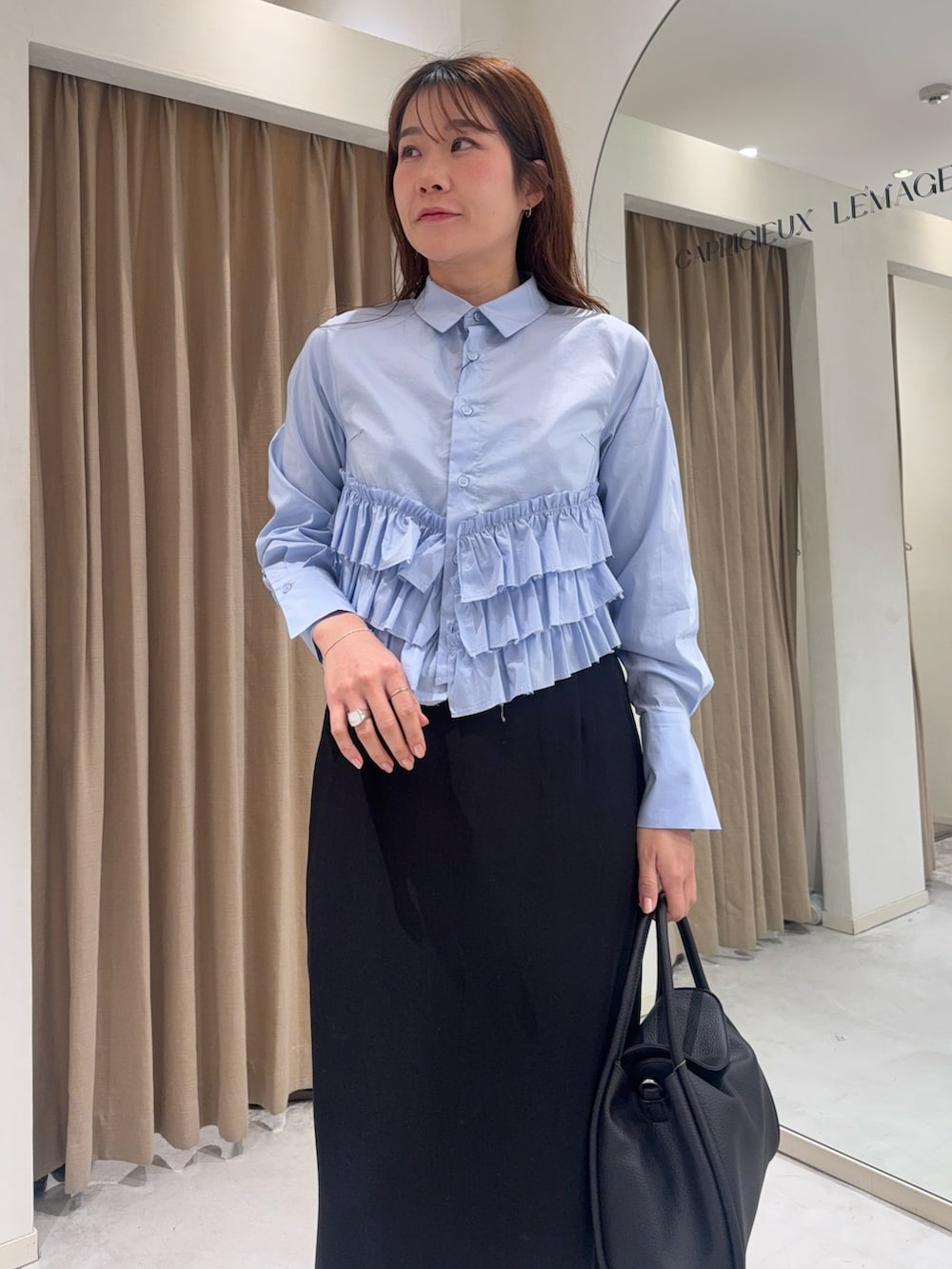 ブルー系のシャツ/ブラウス、ブラック系のショルダーバッグ、ブラック系のスカートを着用したレディースの冬コーディネートの5枚目の写真