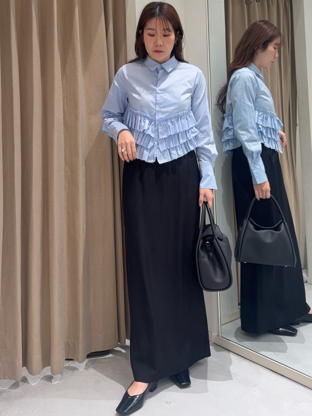 ブルー系のシャツ/ブラウス、ブラック系のショルダーバッグ、ブラック系のスカートを着用したレディースの冬コーディネートの2枚目の写真