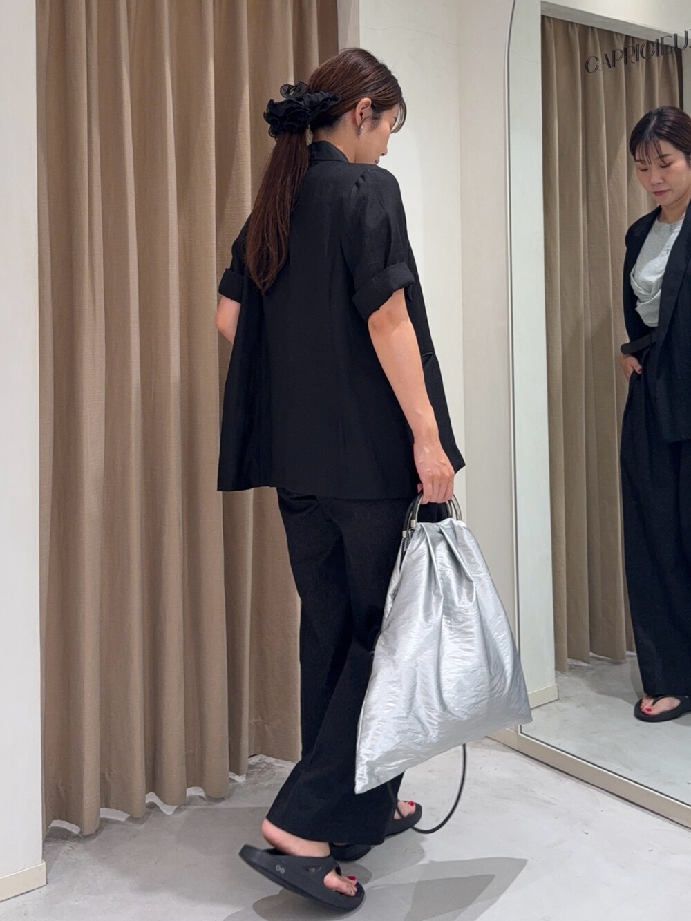 ブラック系のテーラードジャケット、グレー系のTシャツ/カットソー、シルバー系のショルダーバッグを着用したレディースの夏コーディネートの3枚目の写真