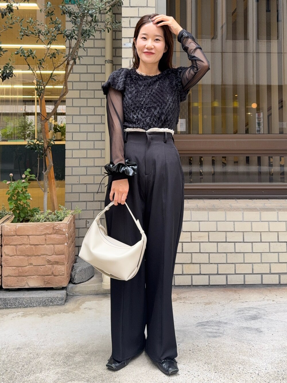 ブラック系のTシャツ/カットソー、ブラック系のその他パンツ、ホワイト系のショルダーバッグを着用したレディースの秋コーディネートの4枚目の写真