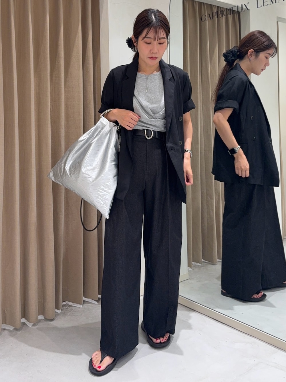 ブラック系のテーラードジャケット、グレー系のTシャツ/カットソー、シルバー系のショルダーバッグを着用したレディースの夏コーディネートの2枚目の写真