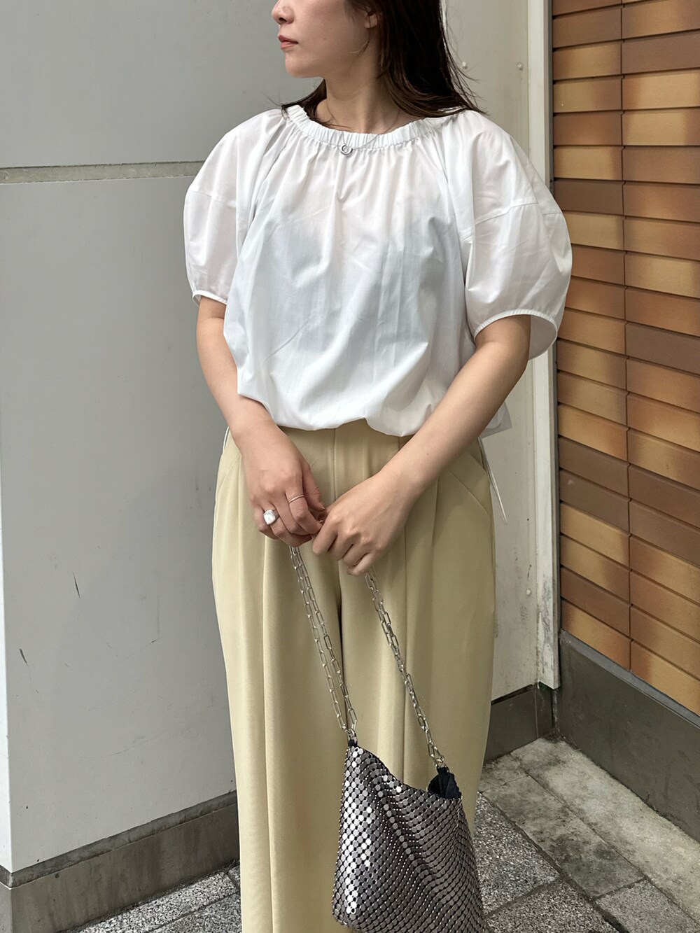 ベージュ系のその他パンツ、ホワイト系のシャツ/ブラウス、シルバー系のショルダーバッグを着用したレディースの春コーディネートの3枚目の写真