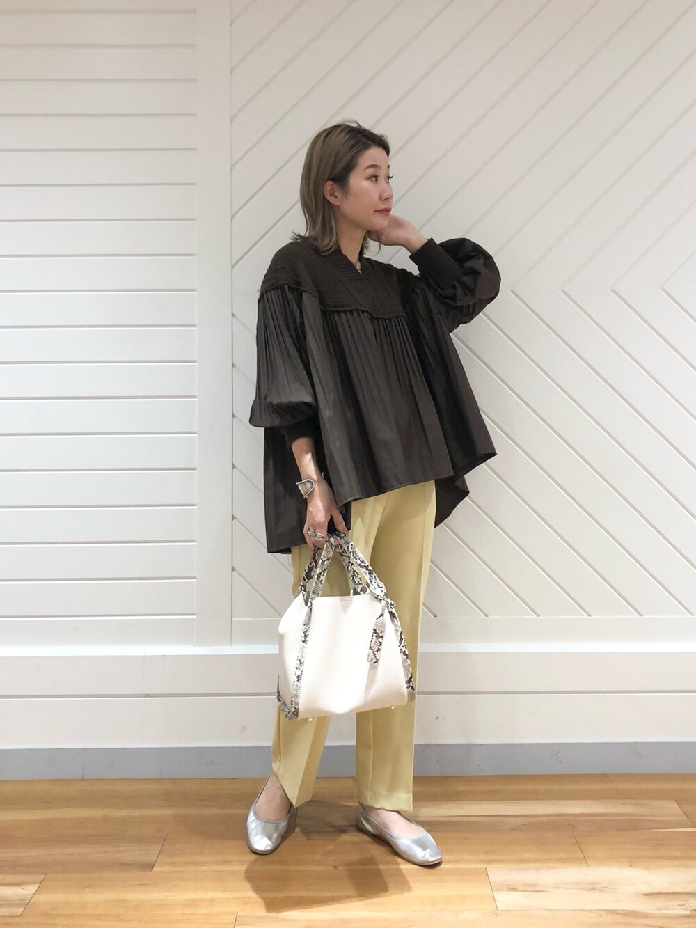 ブラウン系のニット/セーター、イエロー系のその他パンツ、シルバー系のパンプスを着用したレディースの秋コーディネートの2枚目の写真