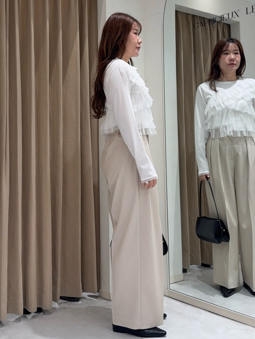 ホワイト系のTシャツ/カットソー、ホワイト系のその他パンツ、ブラック系のショルダーバッグを着用したレディースの冬コーディネートの2枚目の写真