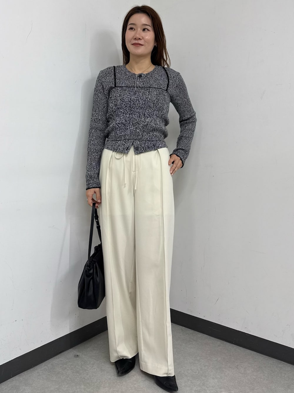 ブラック系のカーディガン/ボレロ、ホワイト系のその他パンツ、ブラック系のショルダーバッグを着用したレディースの冬コーディネートの2枚目の写真