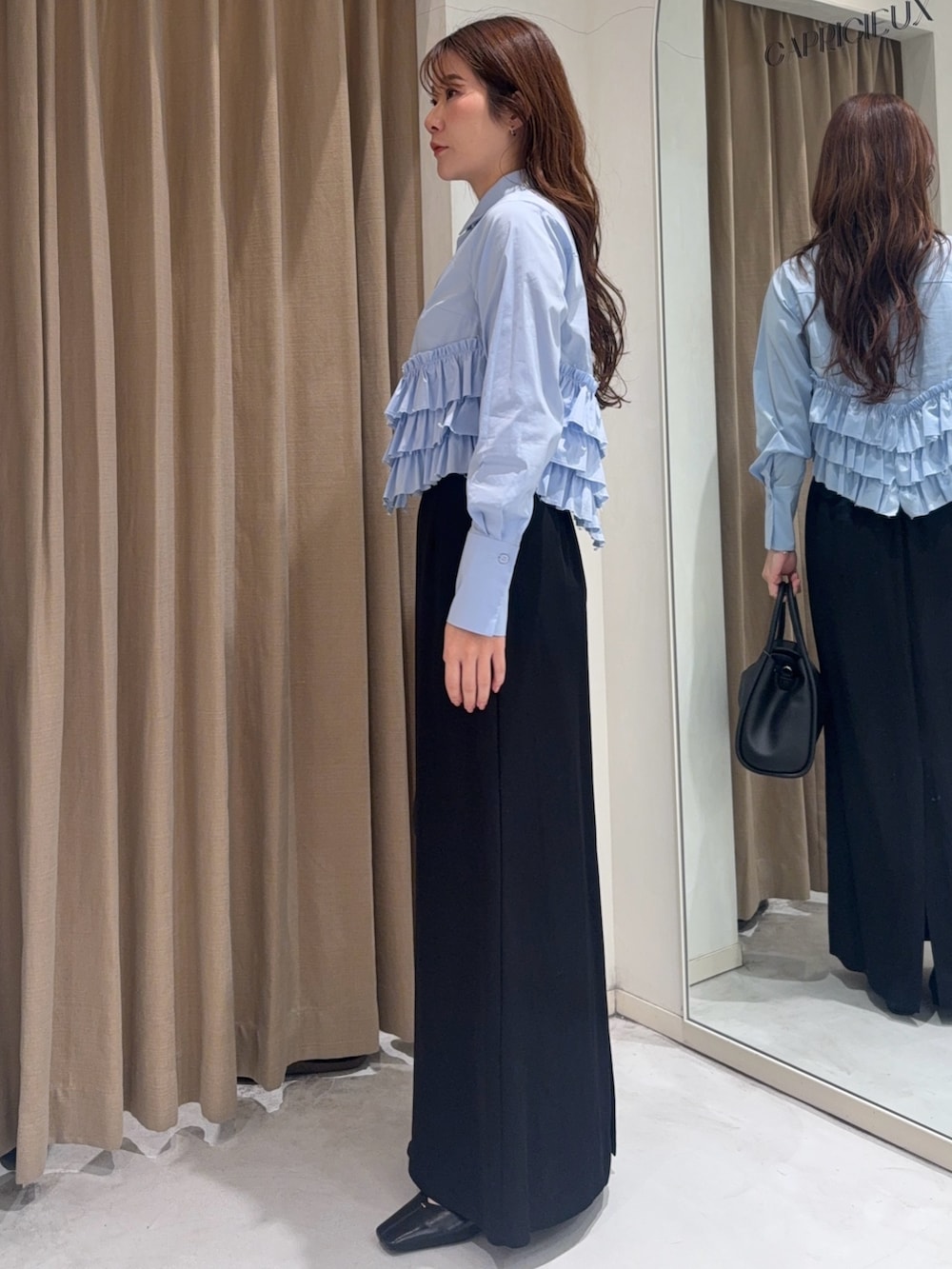 ブルー系のシャツ/ブラウス、ブラック系のショルダーバッグ、ブラック系のスカートを着用したレディースの冬コーディネートの3枚目の写真