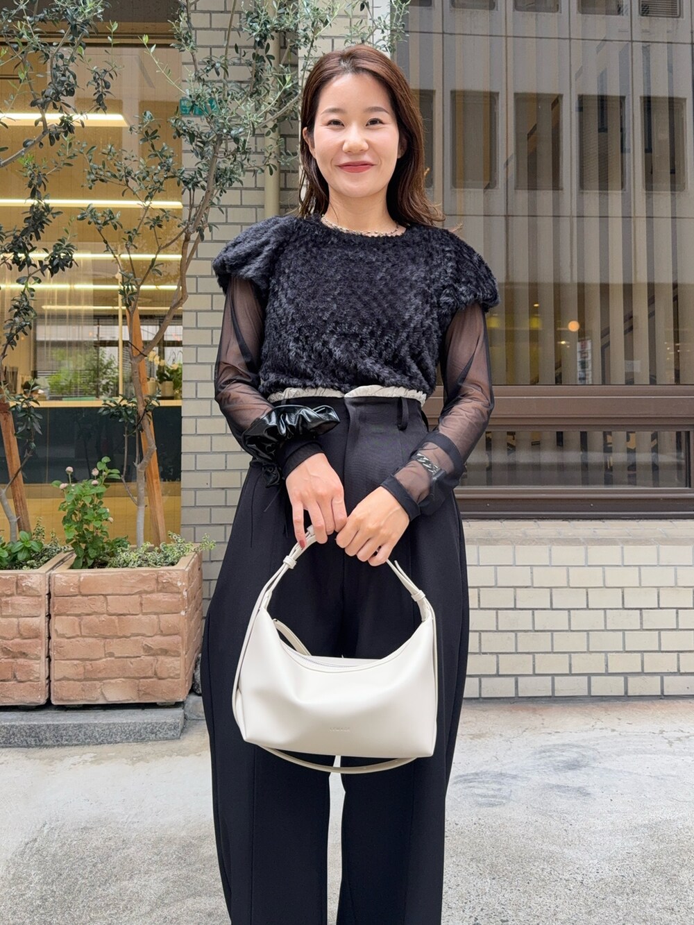 ブラック系のTシャツ/カットソー、ブラック系のその他パンツ、ホワイト系のショルダーバッグを着用したレディースの秋コーディネートの5枚目の写真