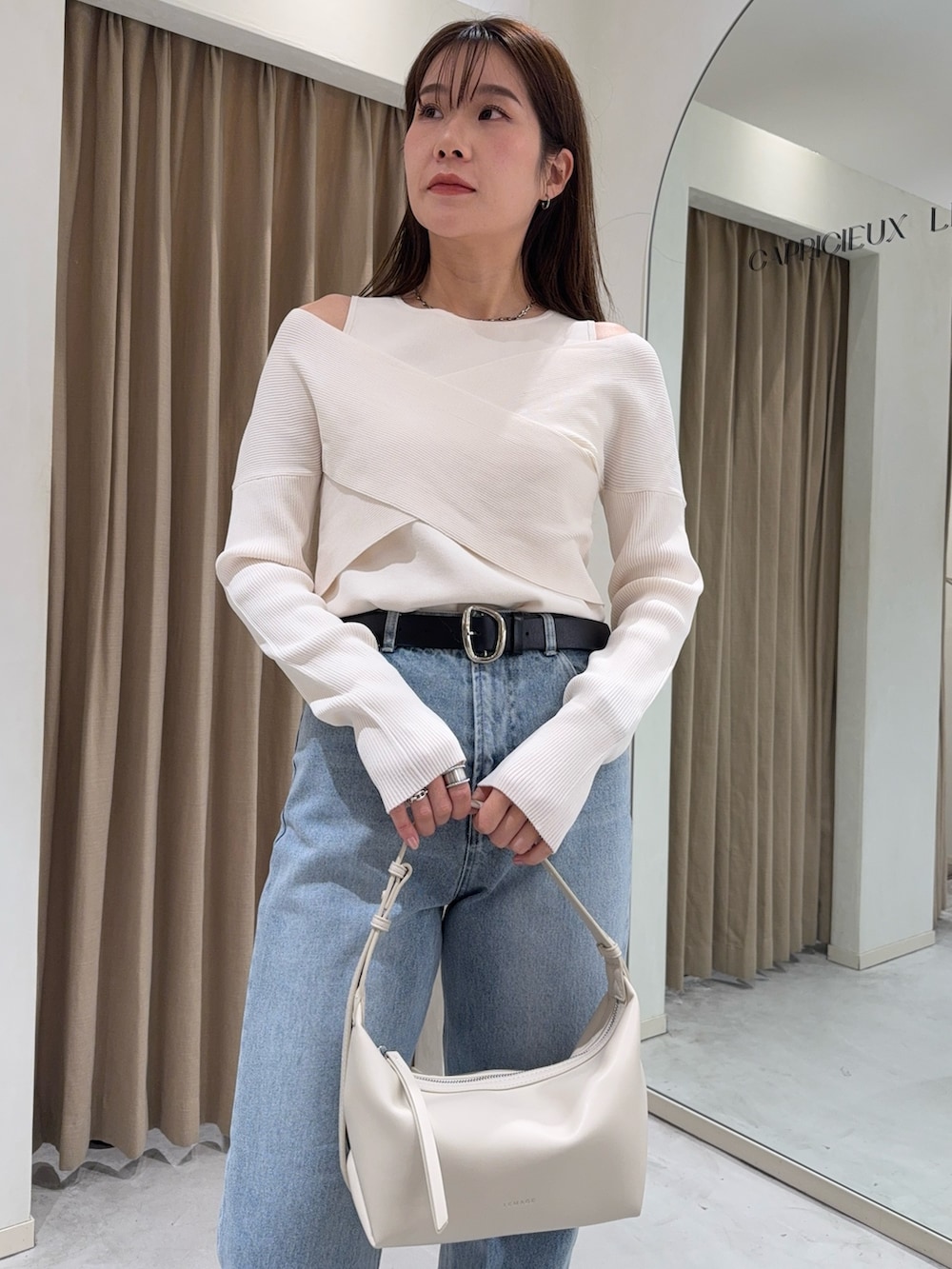 ホワイト系のニット/セーター、ブラック系のパンプス、ホワイト系のショルダーバッグを着用したレディースの冬コーディネートの6枚目の写真