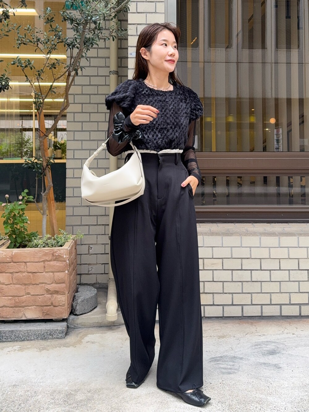 ブラック系のTシャツ/カットソー、ブラック系のその他パンツ、ホワイト系のショルダーバッグを着用したレディースの秋コーディネートの2枚目の写真
