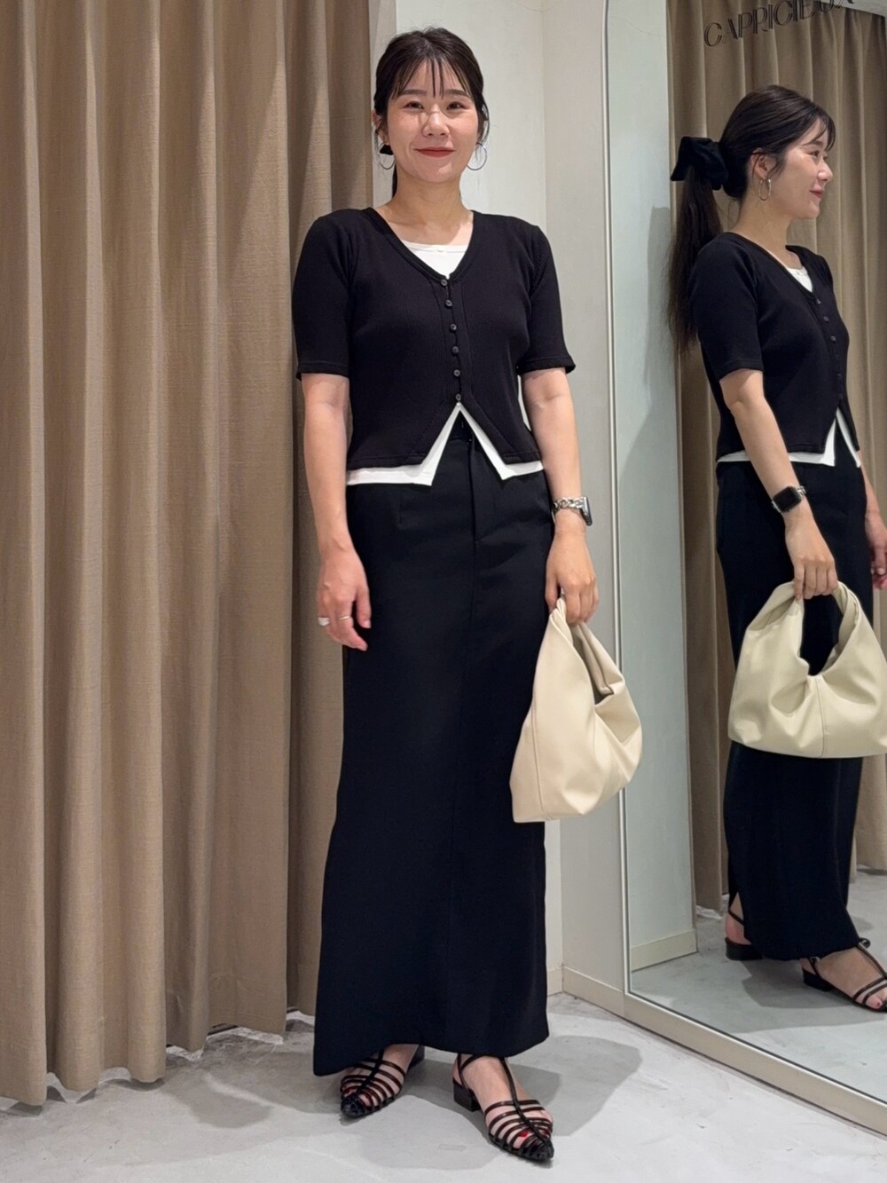 ブラック系のTシャツ/カットソー、ホワイト系のショルダーバッグ、ブラック系のスカートを着用したレディースの夏コーディネートの2枚目の写真