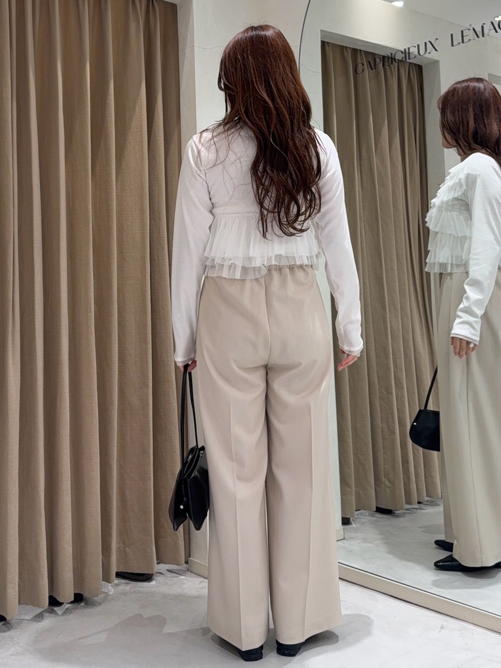 ホワイト系のTシャツ/カットソー、ホワイト系のその他パンツ、ブラック系のショルダーバッグを着用したレディースの冬コーディネートの3枚目の写真