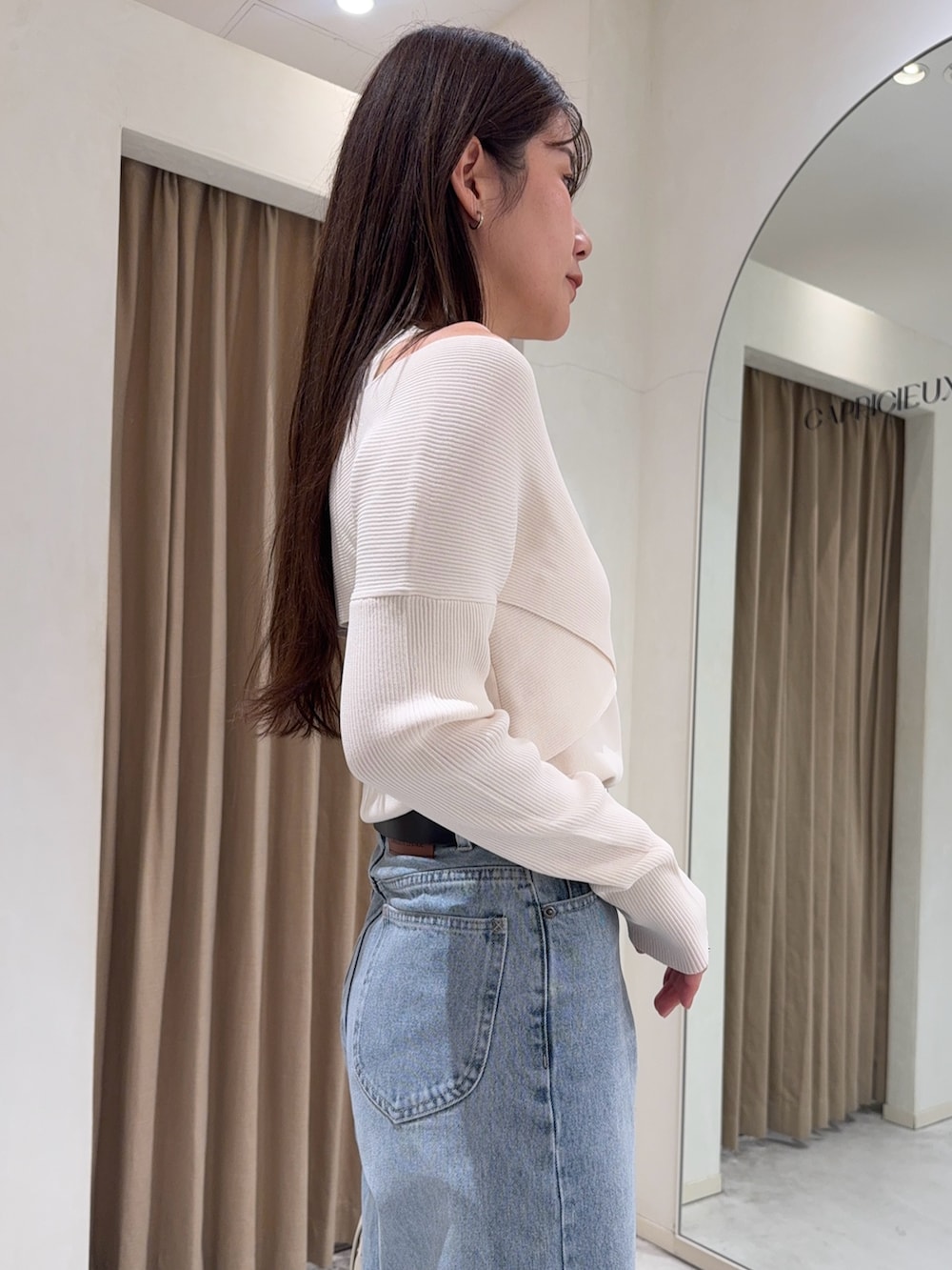 ホワイト系のニット/セーター、ブラック系のパンプス、ホワイト系のショルダーバッグを着用したレディースの冬コーディネートの7枚目の写真