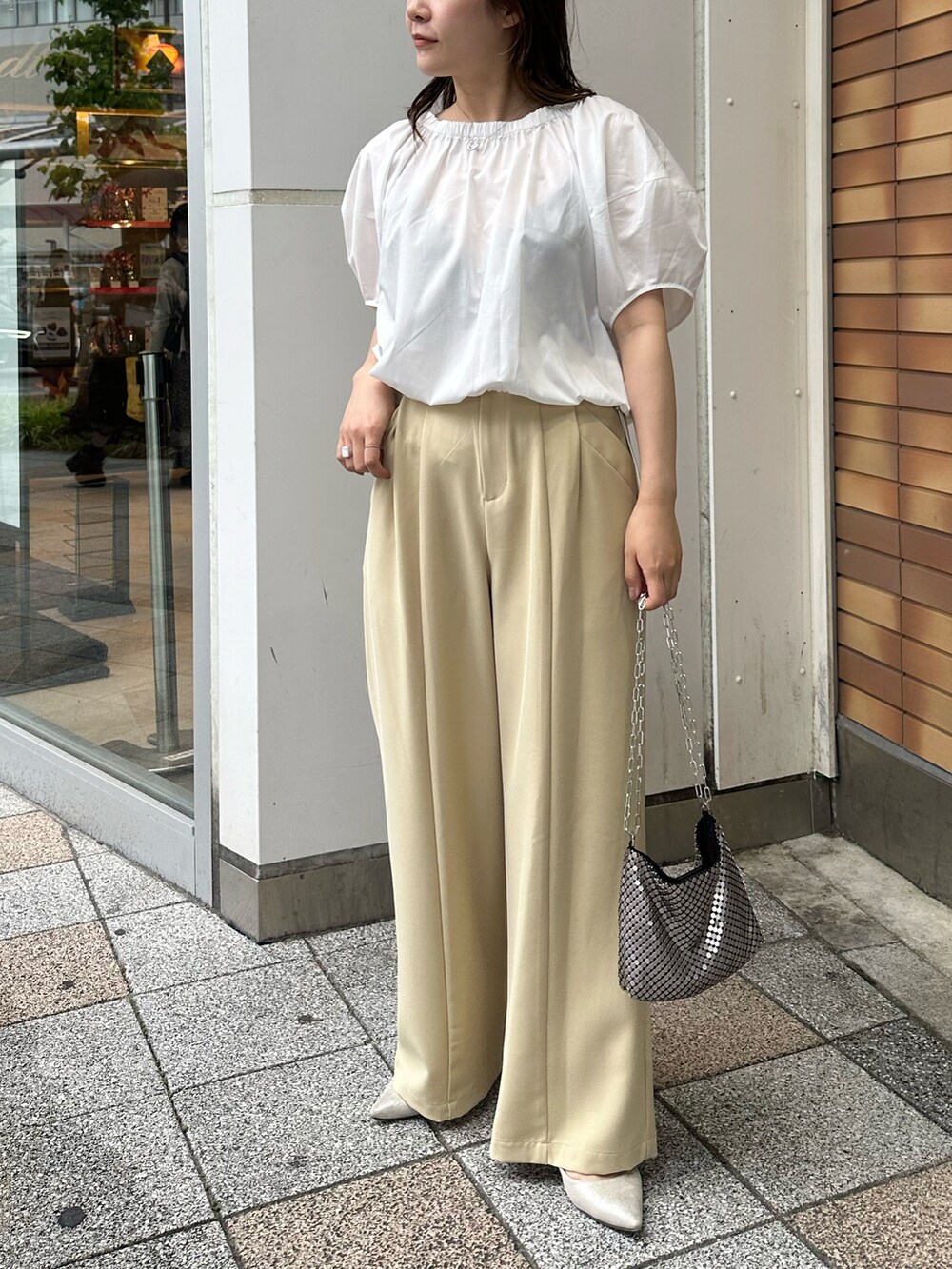 ベージュ系のその他パンツ、ホワイト系のシャツ/ブラウス、シルバー系のショルダーバッグを着用したレディースの春コーディネートの2枚目の写真