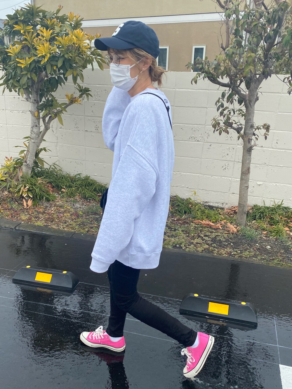 グレー系のスウェット、ブラック系のショルダーバッグ、ピンク系のスニーカーを着用したレディースの春コーディネートの2枚目の写真