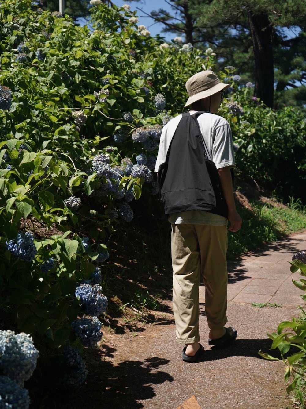 ブラック系のジャケット/アウター、ベージュ系のパンツ、ブラック系のサンダルを着用したメンズの夏コーディネートの2枚目の写真