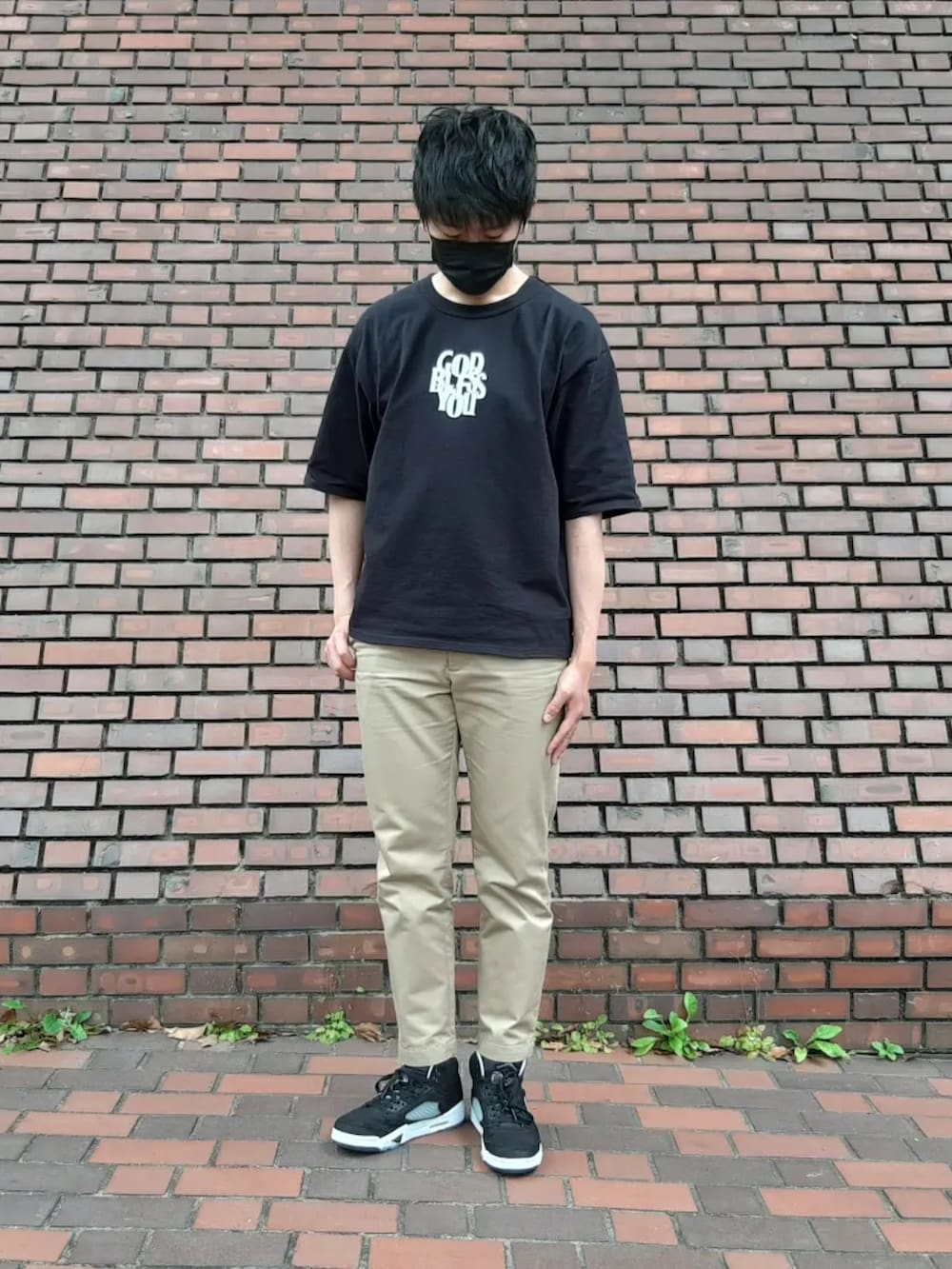 ベージュ系のチノパンツ、ブラック系のTシャツ/カットソー、ブラック系のスニーカーを着用したメンズの夏コーディネートの2枚目の写真