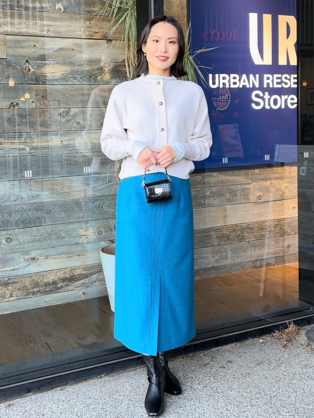 ブルー系のTシャツ/カットソー、ブラック系のショルダーバッグ、ブラック系のブーツを着用したレディースの冬コーディネートの4枚目の写真