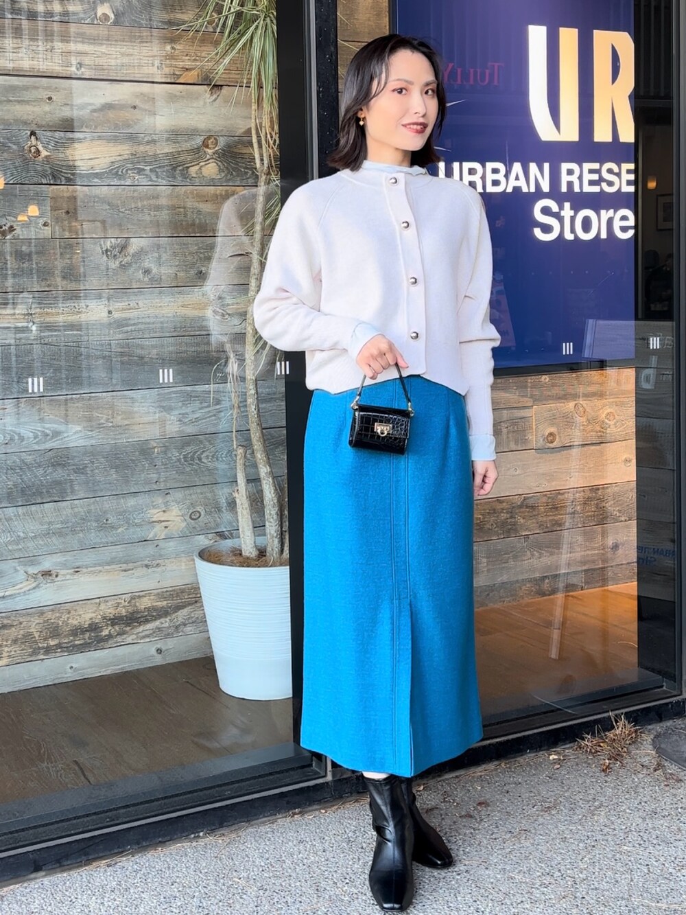 ブルー系のTシャツ/カットソー、ブラック系のショルダーバッグ、ブラック系のブーツを着用したレディースの冬コーディネートの3枚目の写真