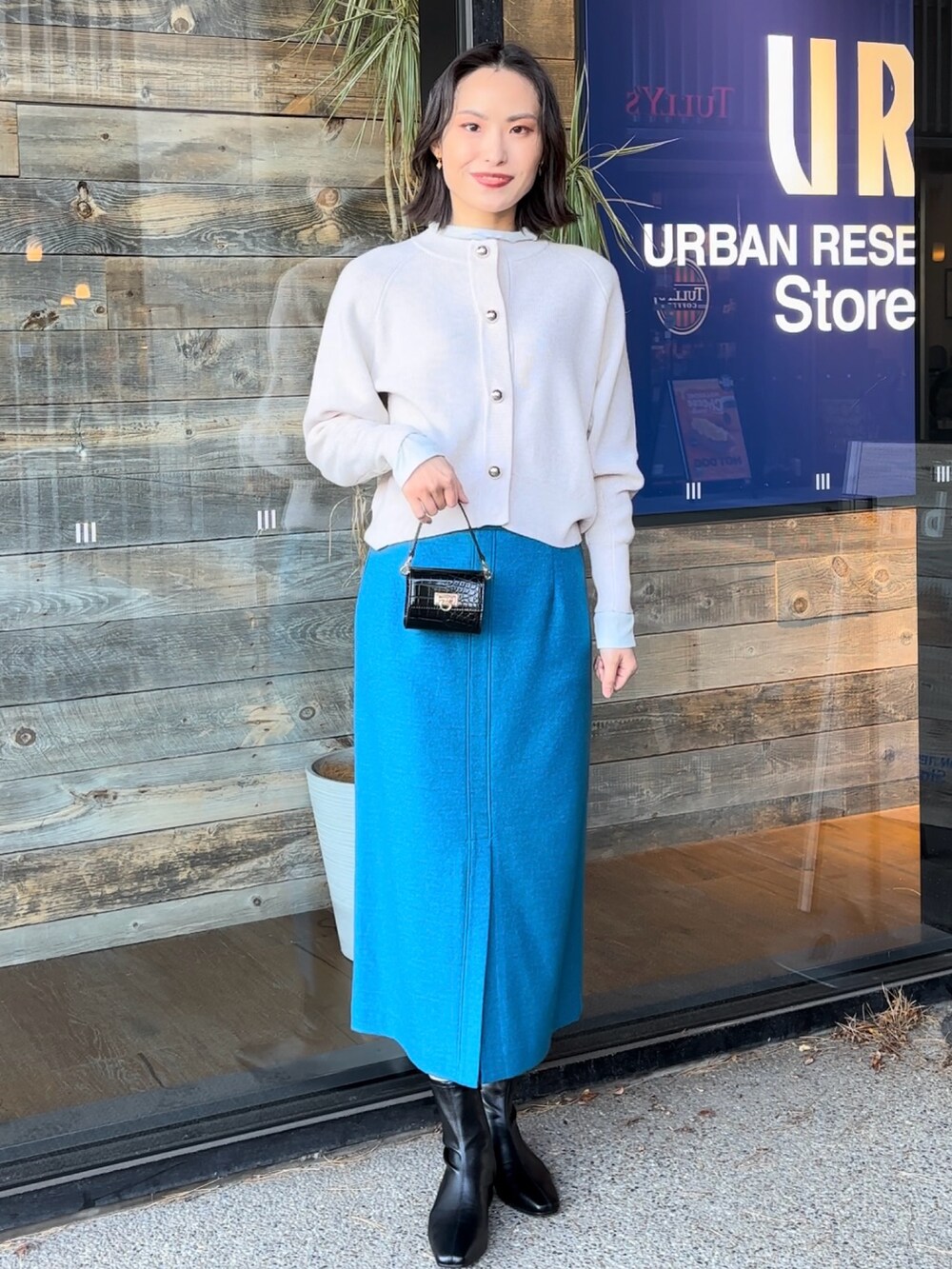 ブルー系のTシャツ/カットソー、ブラック系のショルダーバッグ、ブラック系のブーツを着用したレディースの冬コーディネートの5枚目の写真