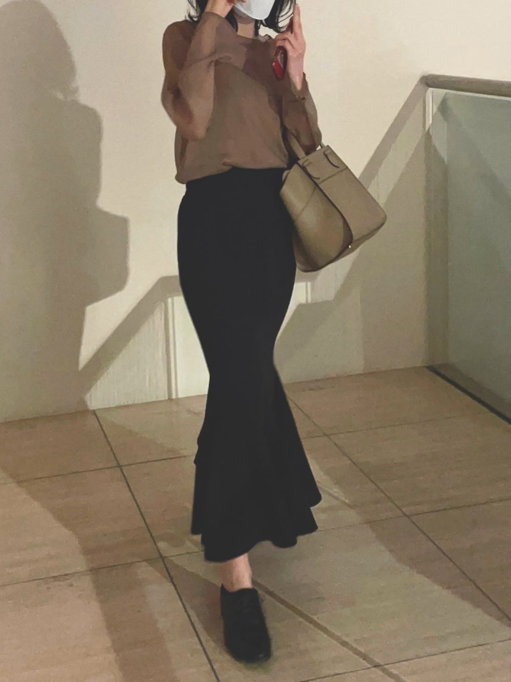 ブラック系のドレスシューズ、ブラック系のスカート、ブラウン系のシャツ/ブラウスを着用したレディースの春コーディネートの2枚目の写真