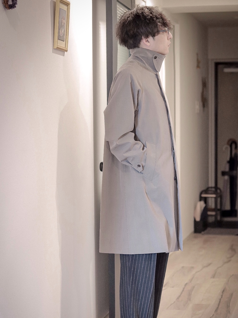 ベージュ系のステンカラーコートを着用したメンズの春コーディネートの2枚目の写真
