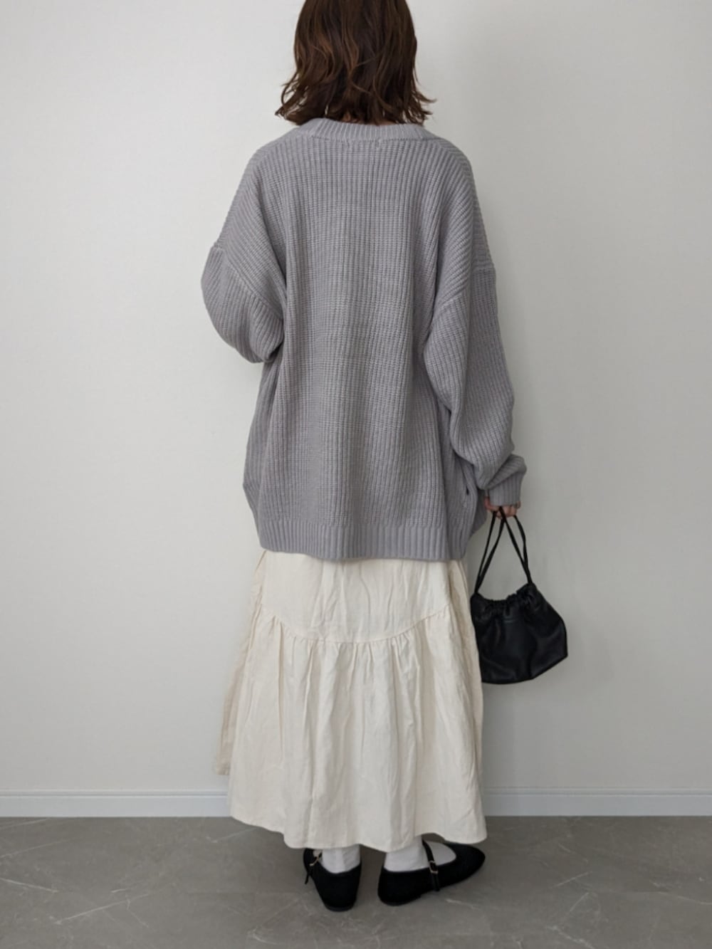 グレー系のカーディガン/ボレロ、ホワイト系のTシャツ/カットソー、ホワイト系のスカートを着用したレディースの秋コーディネートの2枚目の写真