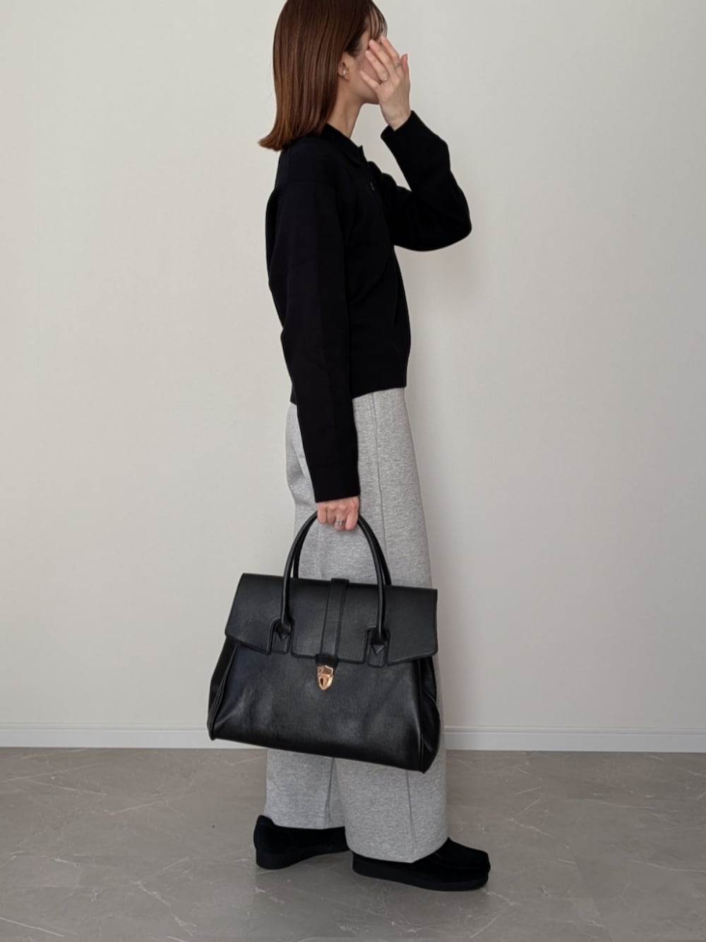 ブラック系のボストンバッグ、グレー系のスウェットパンツ、ブラック系のニット/セーターを着用したレディースの冬コーディネートの2枚目の写真