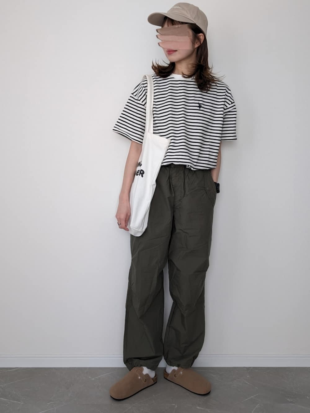 ホワイト系のTシャツ/カットソー、ブラック系のカーゴパンツ、ベージュ系のサンダルを着用したレディースの春コーディネートの2枚目の写真