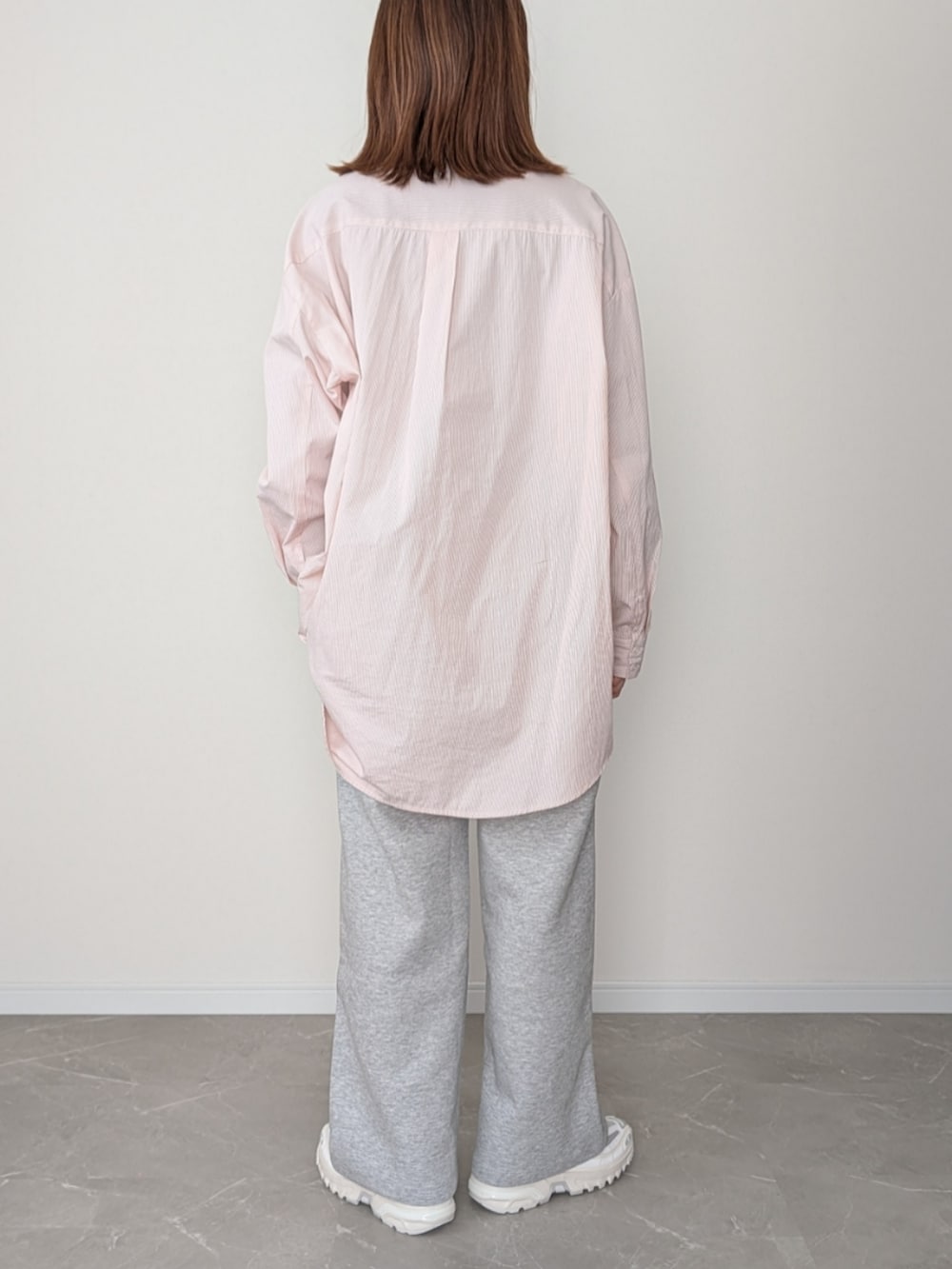 グレー系のスウェットパンツ、ピンク系のシャツ/ブラウス、ホワイト系のスニーカーを着用したレディースの冬コーディネートの3枚目の写真