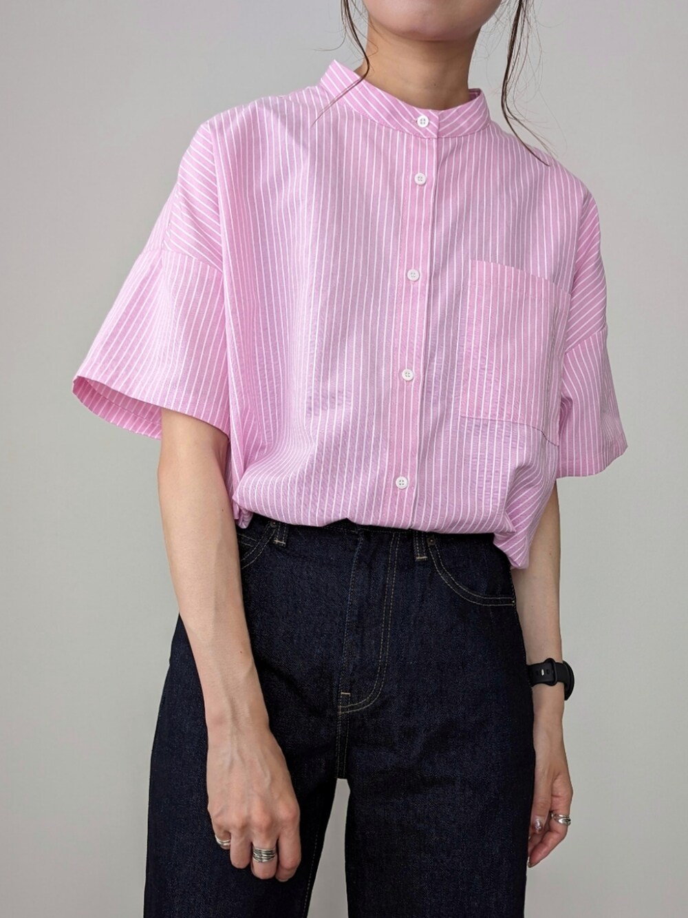 ブルー系のデニムパンツ、ブラック系のサンダル、ピンク系のシャツ/ブラウスを着用したレディースの夏コーディネートの2枚目の写真