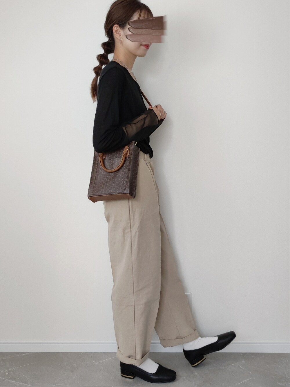 ブラウン系のショルダーバッグ、ブラック系のTシャツ/カットソー、ブラック系のパンプスを着用したレディースの夏コーディネートの2枚目の写真