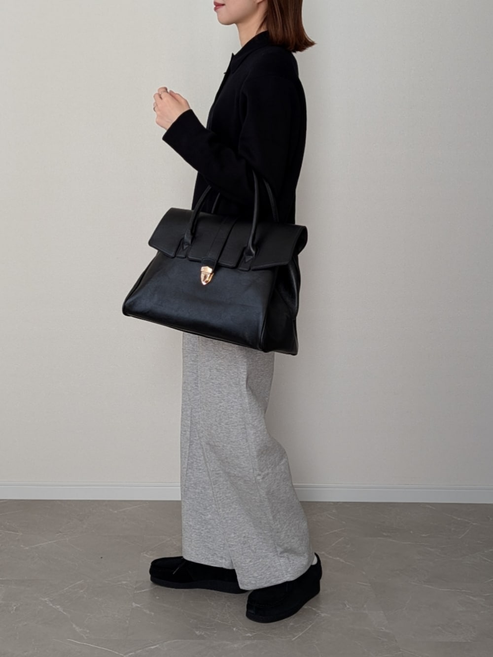 ブラック系のボストンバッグ、グレー系のスウェットパンツ、ブラック系のニット/セーターを着用したレディースの冬コーディネートの4枚目の写真