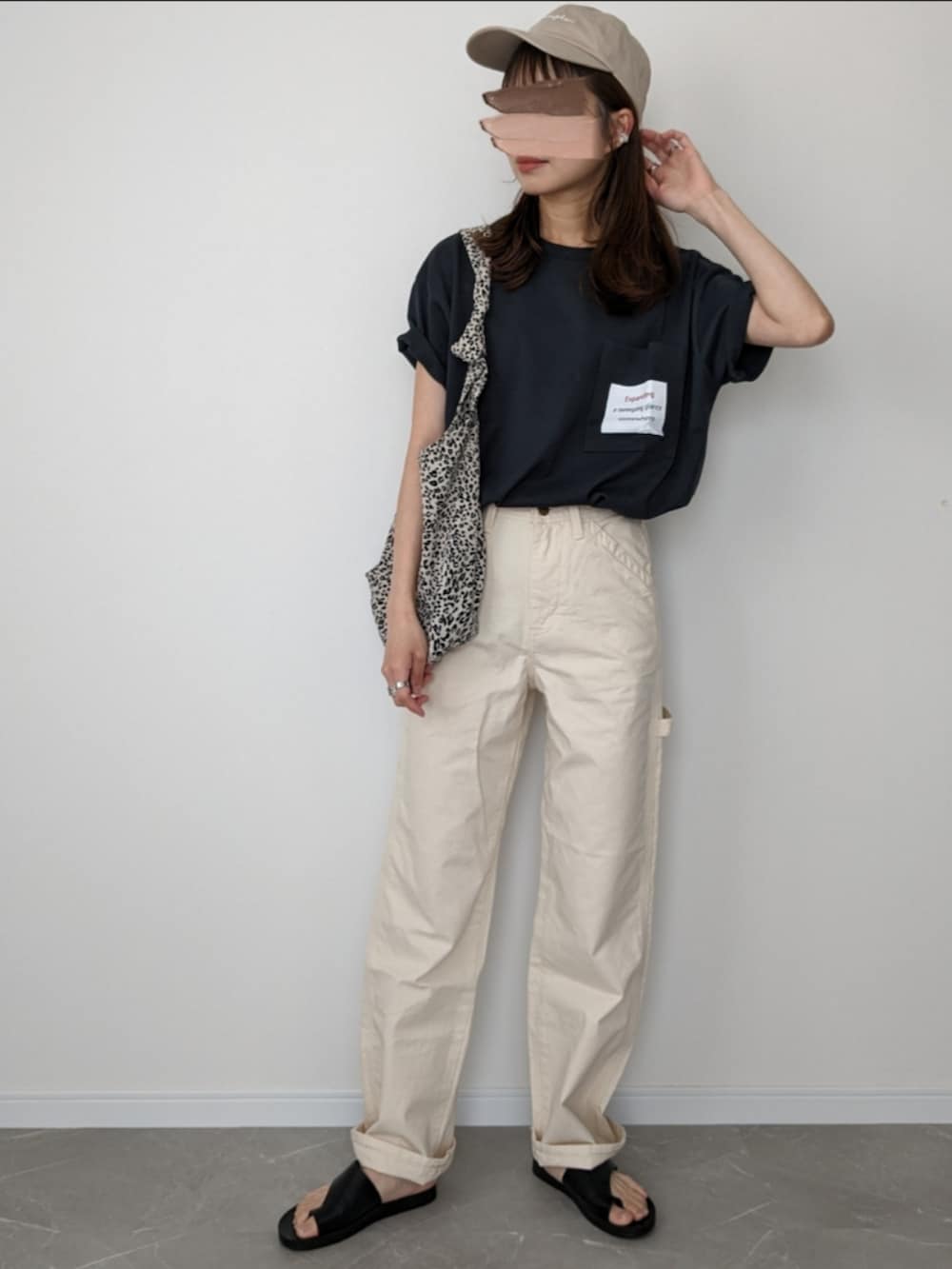 ブラック系のTシャツ/カットソー、ホワイト系のデニムパンツ、ブラック系のサンダルを着用したレディースの春コーディネートの2枚目の写真