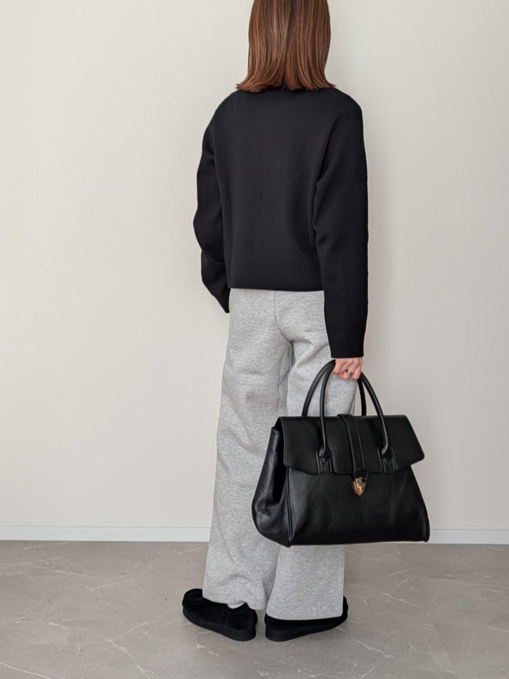 ブラック系のボストンバッグ、グレー系のスウェットパンツ、ブラック系のニット/セーターを着用したレディースの冬コーディネートの3枚目の写真