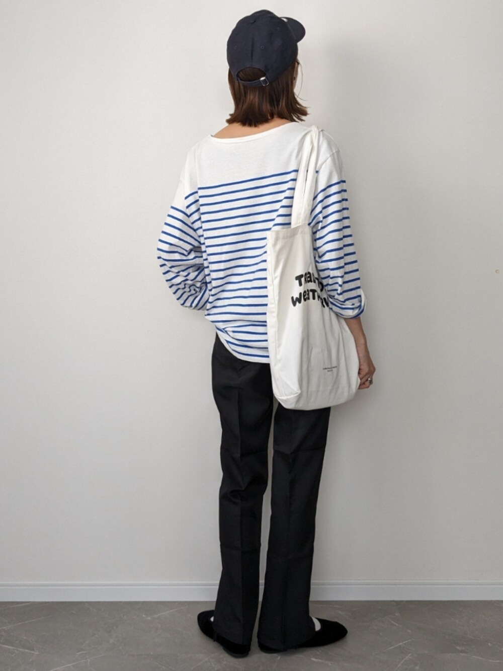 ブラック系のスラックス、ブルー系のTシャツ/カットソー、ブルー系のトートバッグを着用したレディースの夏コーディネートの2枚目の写真