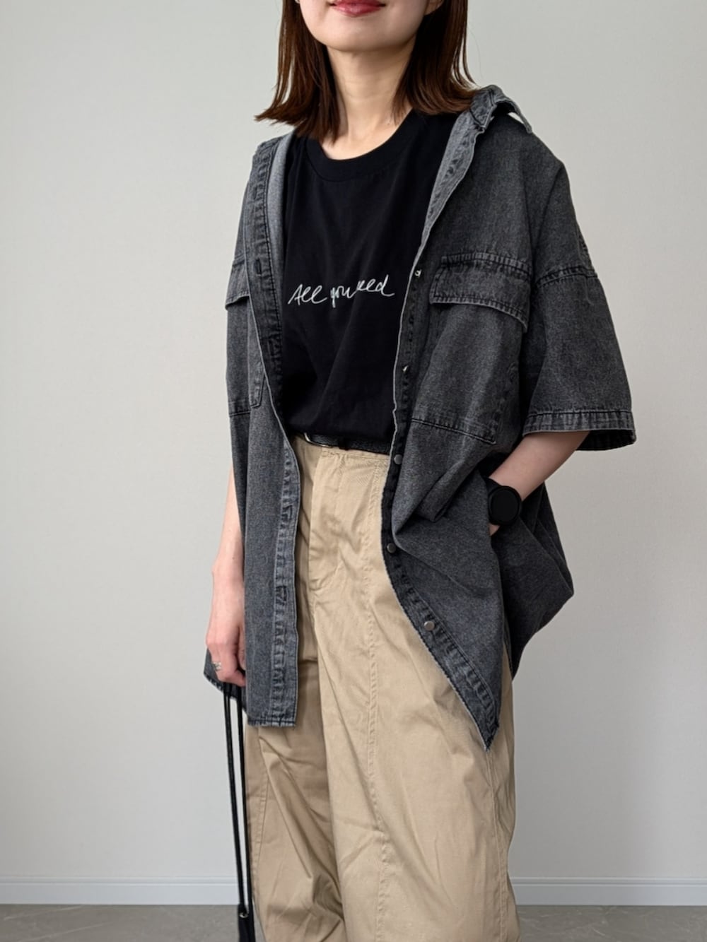 ブラック系のシャツ/ブラウス、ブラック系のTシャツ/カットソー、ベージュ系のチノパンツを着用したレディースの春コーディネートの2枚目の写真