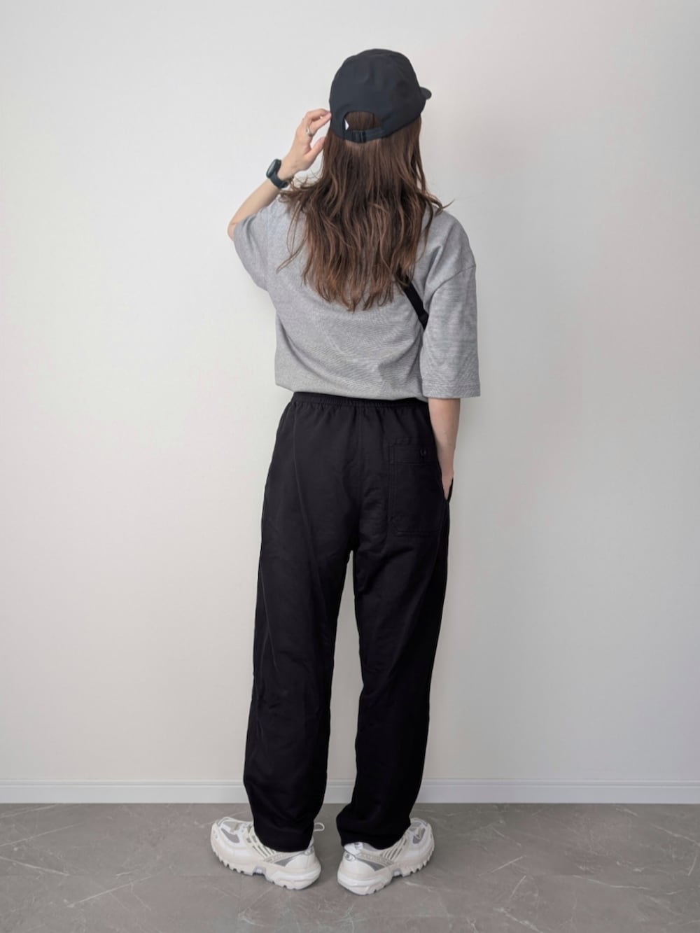 ブラック系のショルダーバッグ、ブラック系のパンツ、ホワイト系のスニーカーを着用したレディースの夏コーディネートの2枚目の写真