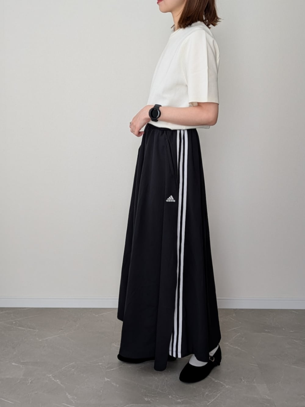 ホワイト系のニット/セーター、ブラック系のスカート、ブラック系のショルダーバッグを着用したレディースの春コーディネートの3枚目の写真