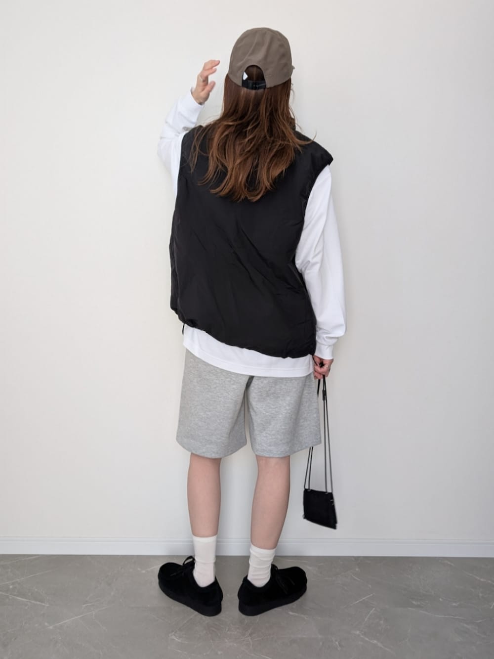 グレー系のスウェットパンツ、ブラック系のベスト、ホワイト系のTシャツ/カットソーを着用したレディースの春コーディネートの2枚目の写真