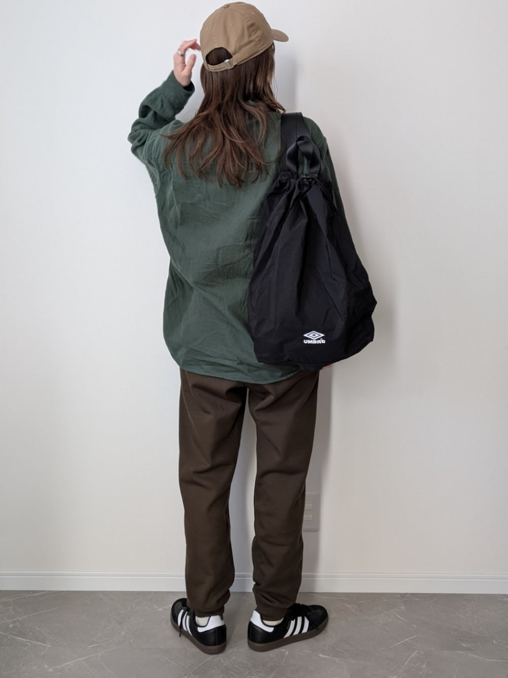 ブラウン系のスウェットパンツ、グリーン系のシャツ/ブラウス、ブラック系のバックパック/リュックを着用したレディースの冬コーディネートの2枚目の写真