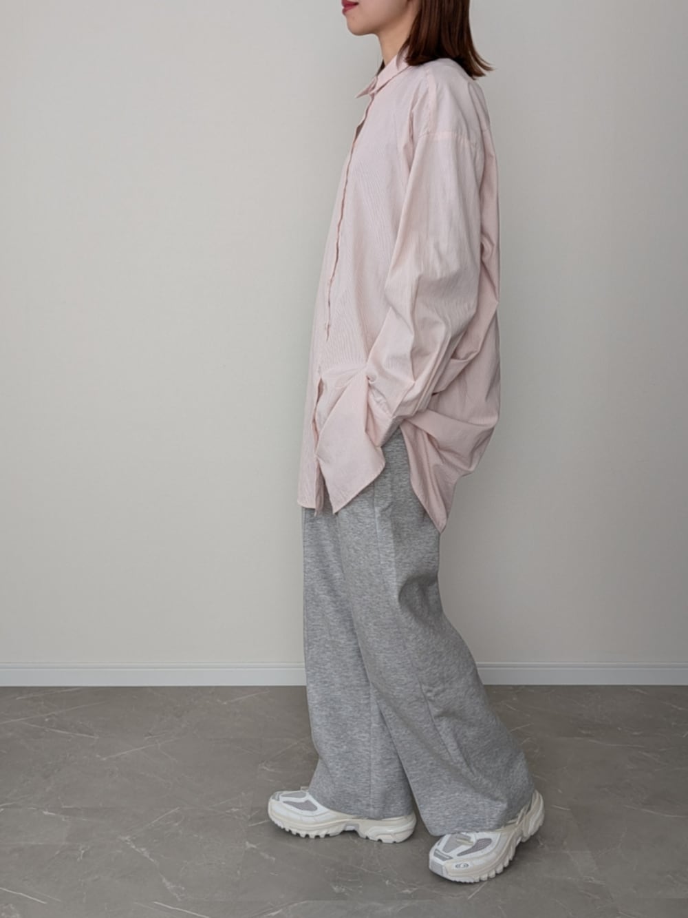 グレー系のスウェットパンツ、ピンク系のシャツ/ブラウス、ホワイト系のスニーカーを着用したレディースの冬コーディネートの2枚目の写真