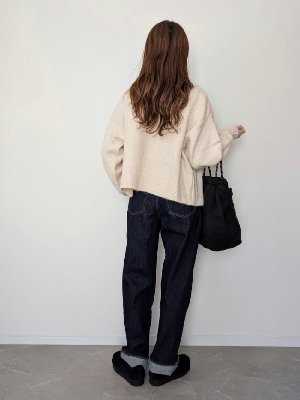ホワイト系のカーディガン/ボレロ、ホワイト系のTシャツ/カットソー、ブルー系のデニムパンツを着用したレディースの秋コーディネートの2枚目の写真