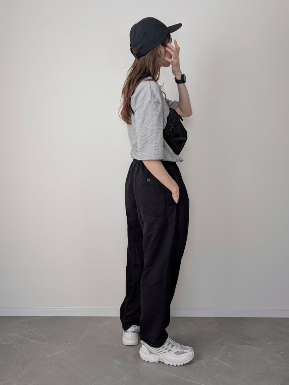 ブラック系のショルダーバッグ、ブラック系のパンツ、ホワイト系のスニーカーを着用したレディースの夏コーディネートの3枚目の写真