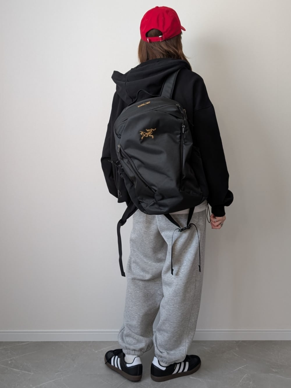 グレー系のスウェットパンツ、ブラック系のパーカー、ブラック系のスニーカーを着用したレディースの冬コーディネートの2枚目の写真