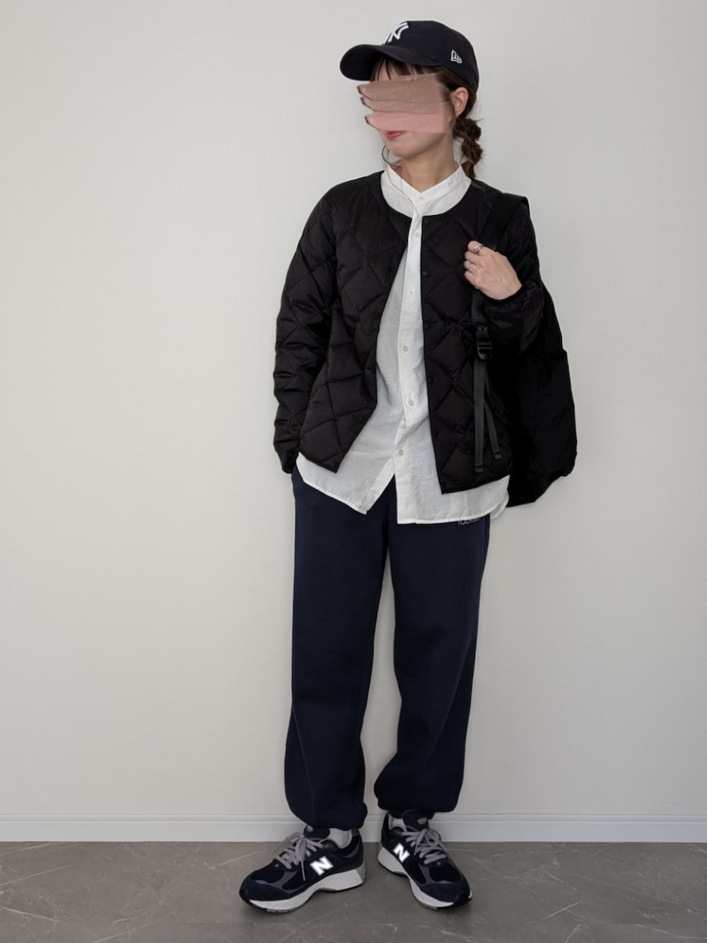 ブラック系のダウンジャケット/コート、ブラック系のバックパック/リュック、ブルー系のスウェットパンツを着用したレディースの冬コーディネートの3枚目の写真